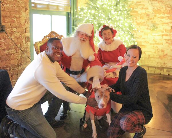 Family and their dog with Santa and Mrs. Claus