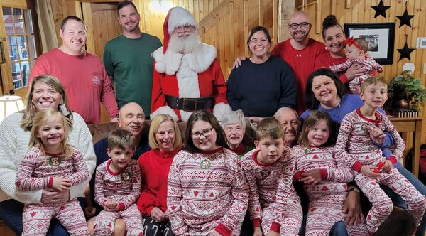 Big family in matching Christmas pajamas with Santa