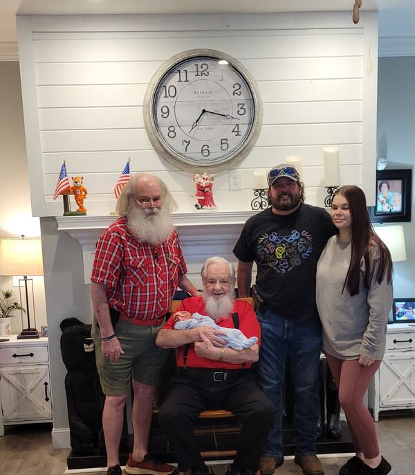 Family with a baby and Santa in a farmhouse kitchen