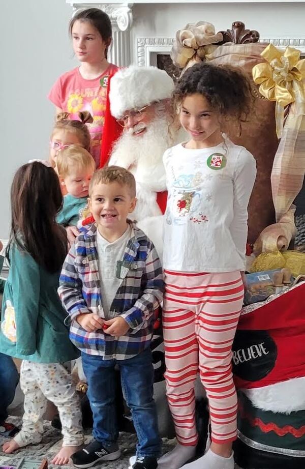 Children gathered around Santa at a home visit