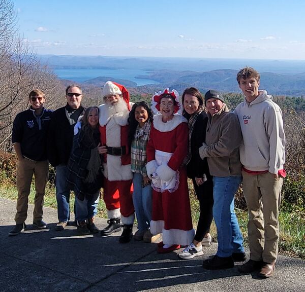 Group photo with Santa and Mrs. Claus at a mountain overlook