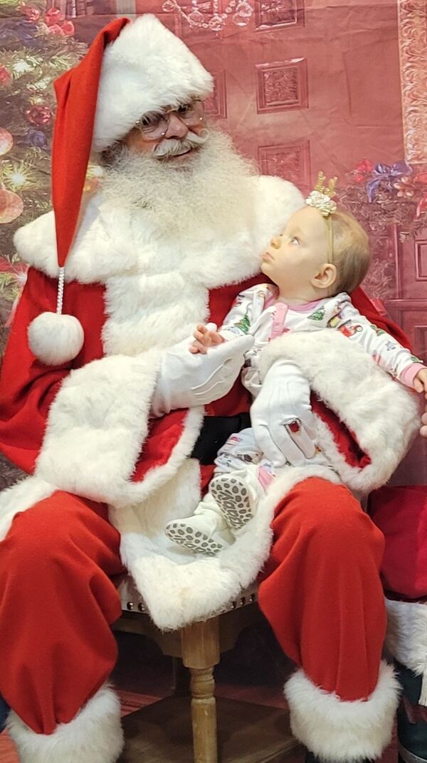 Baby girl looking up at Santa Truette
