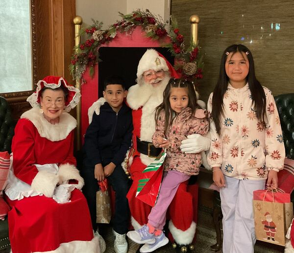 Three children with Santa and Mrs. Claus