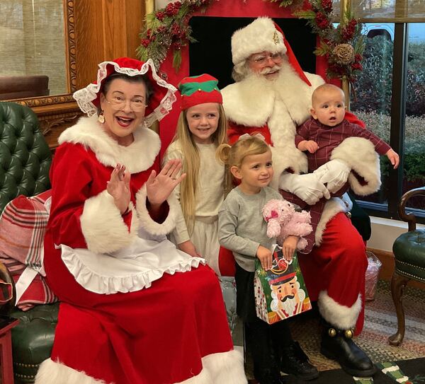 Children and a baby with Santa and Mrs. Claus at a holiday party