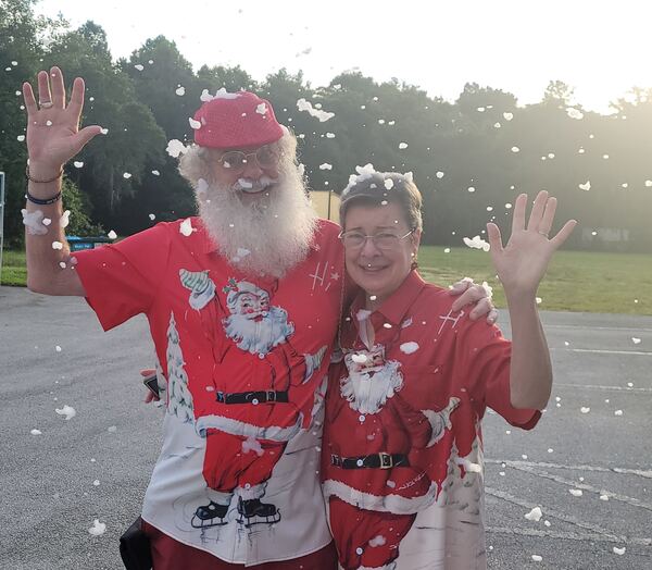 Santa and Mrs. Claus waving in summer Christmas shirts