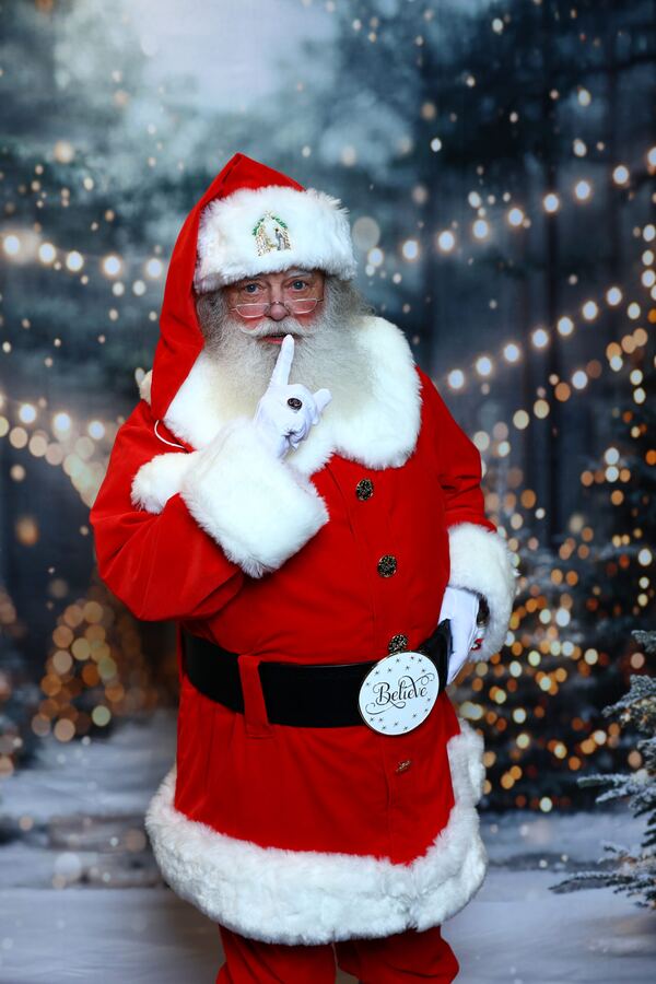 Santa Truette with a finger to his lips in a snowy forest