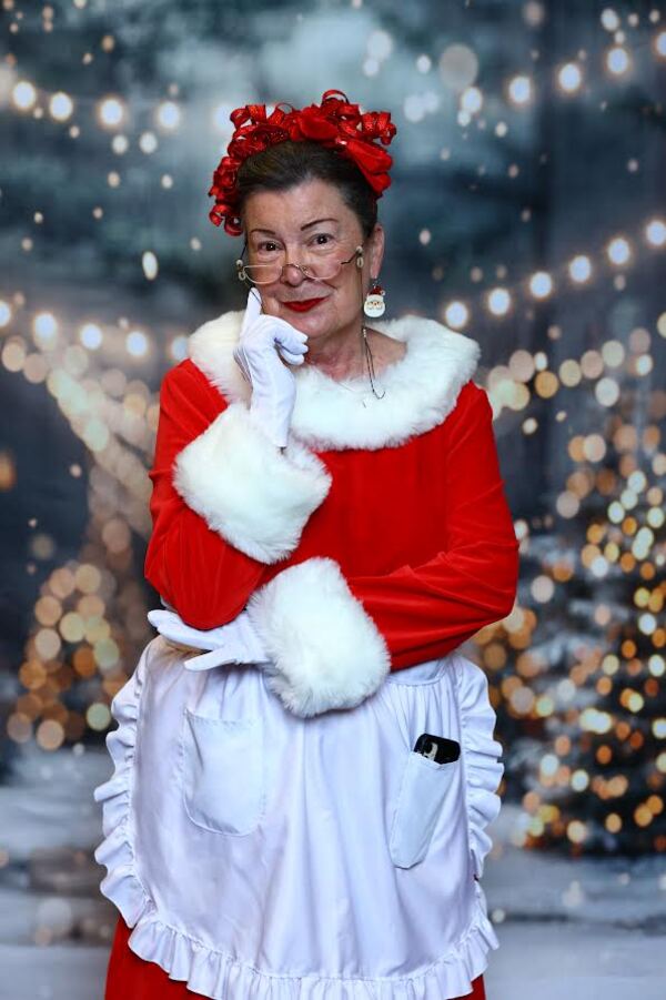 Mrs. Claus Nancy smiling with a finger to her cheek