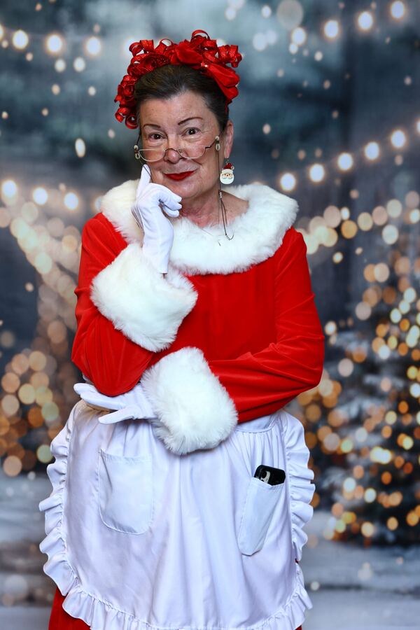 Mrs. Claus Nancy with her hand to her chin in a snowy forest