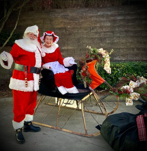 Santa Truette and Mrs. Claus Nancy with a vintage sleigh