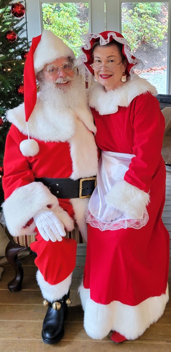 Santa Truette and Mrs. Claus Nancy side by side next to a Christmas tree