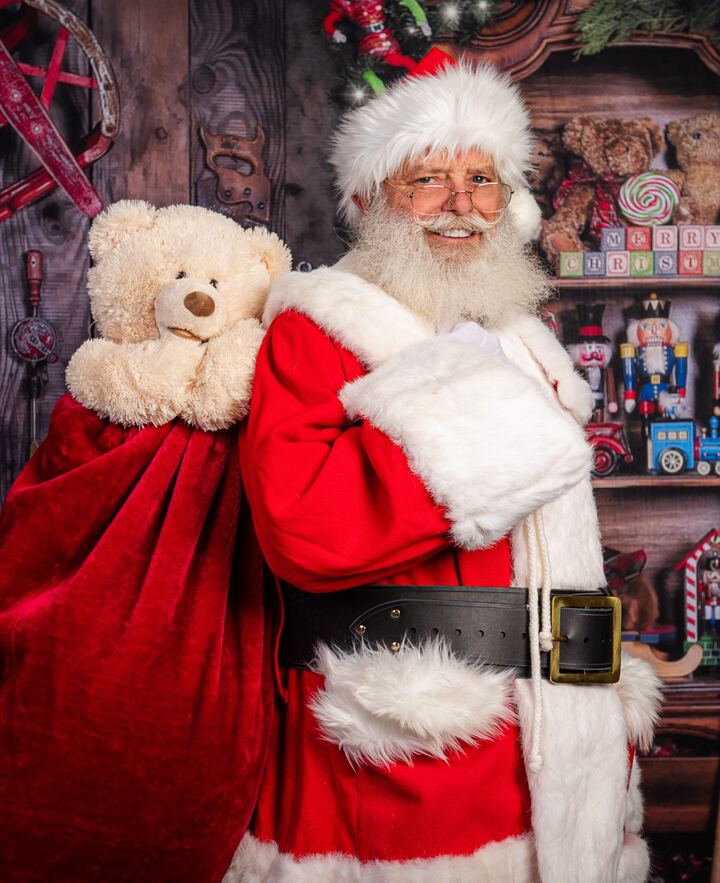 Santa Truette with a teddy bear and his bag of toys